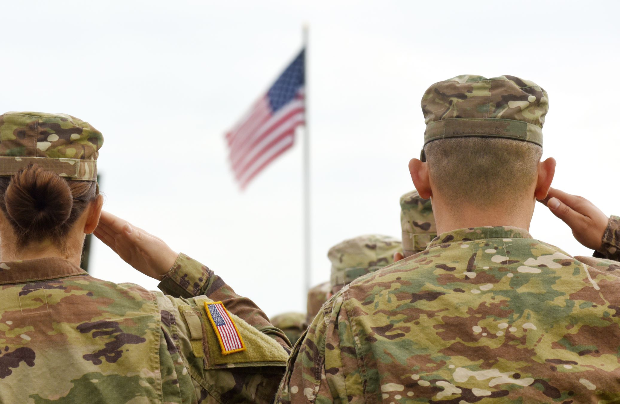Army men saluting US flag
